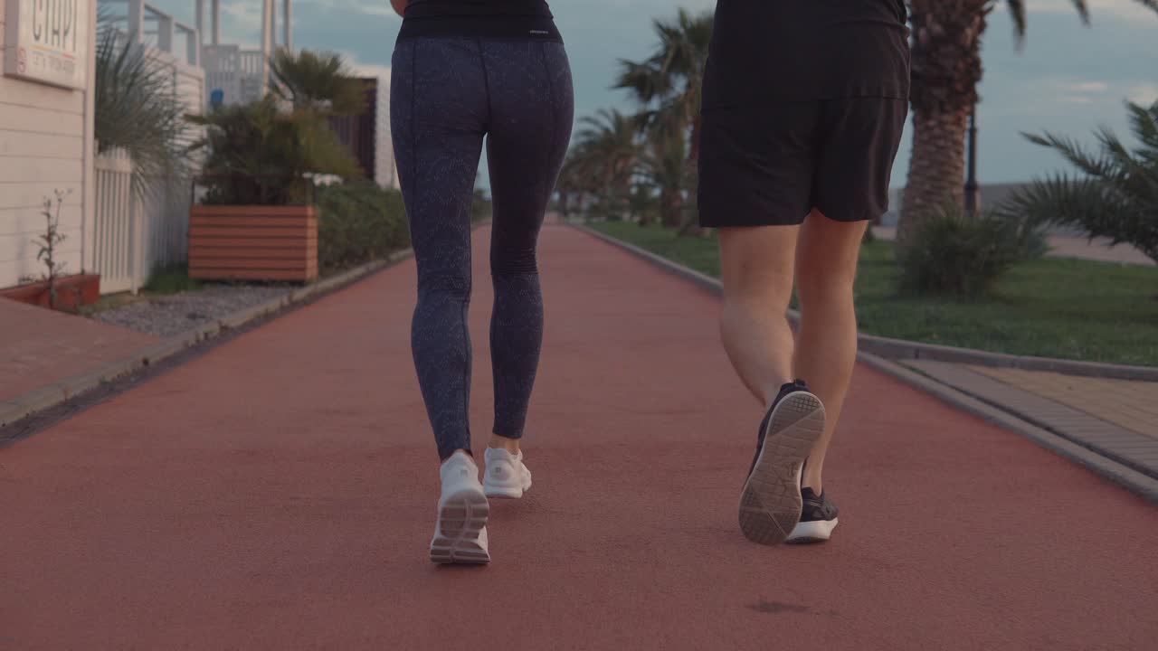 pareja corriendo por un camino de la playa