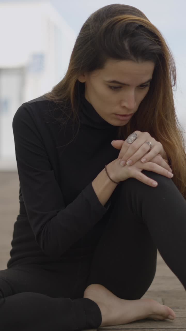 Pensive Woman Sitting Alone on a Wooden Floor