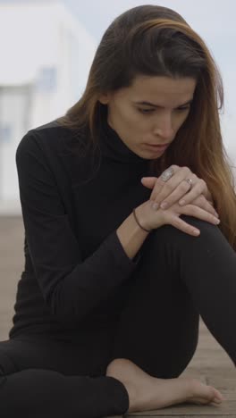pensive woman sitting alone on a wooden floor