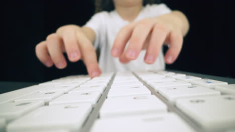 playful-girl-presses-keys-of-modern-computer-keyboard