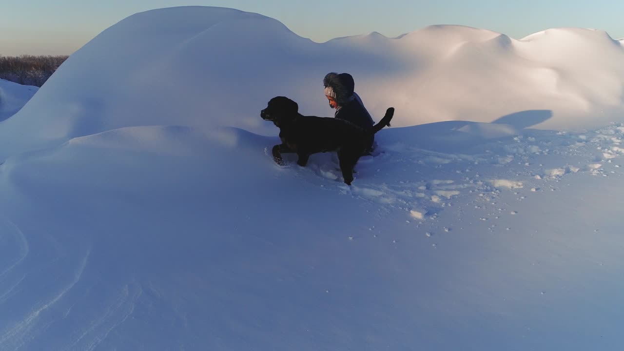 niño alegre jugando con el perro en la nieve