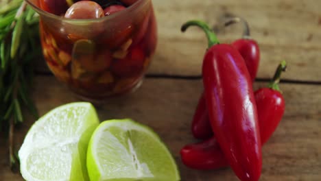 ingredients red chili pepper, red olives and lemon kept on wooden table