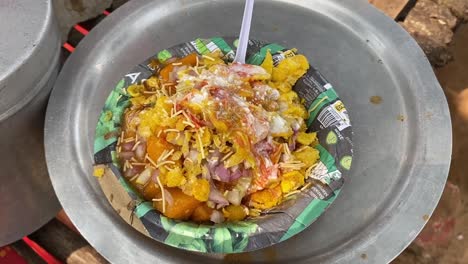 una foto cercana de aloo tikki chaat, un bocadillo indio que hace agua en la boca que se ha servido en un puesto de comida en la carretera durante el día