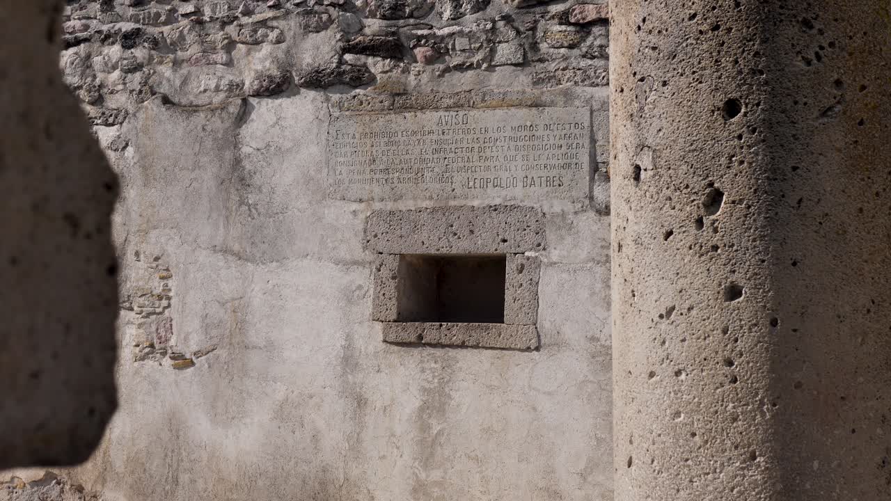 Slow motion landscape of ancient tomb ruins stone rock wall with historic sacred writing script Zapotec culture Mitla archaeology landmark monument Oaxaca Mexico travel
