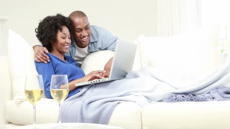Attractive-couple-using-laptop-on-the-couch
