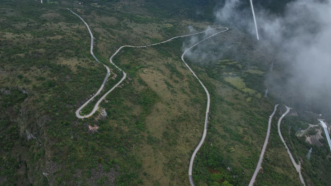 Winding mountain road in cetinje, montenegro, surrounded by greenery, aerial view