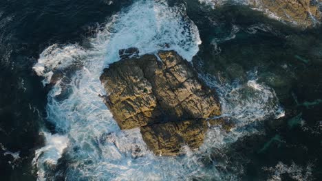 Overhead-View-Of-Ocean-Waves-Crashing-On-The-Rocky-Outcrop