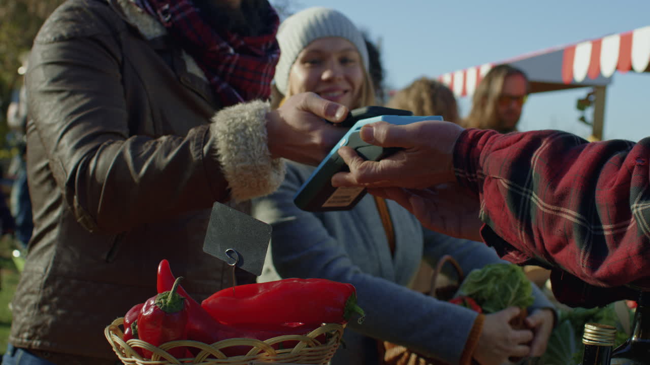 Spouses Shopping on Local Farmers Market Spouses Shopping on Local Farmers Market Wife Stands with Basket of Fruits or Vegetables Husband Pays for Purchase by Contactless Way Vegetarian and Organic Food Agriculture Closeup View
