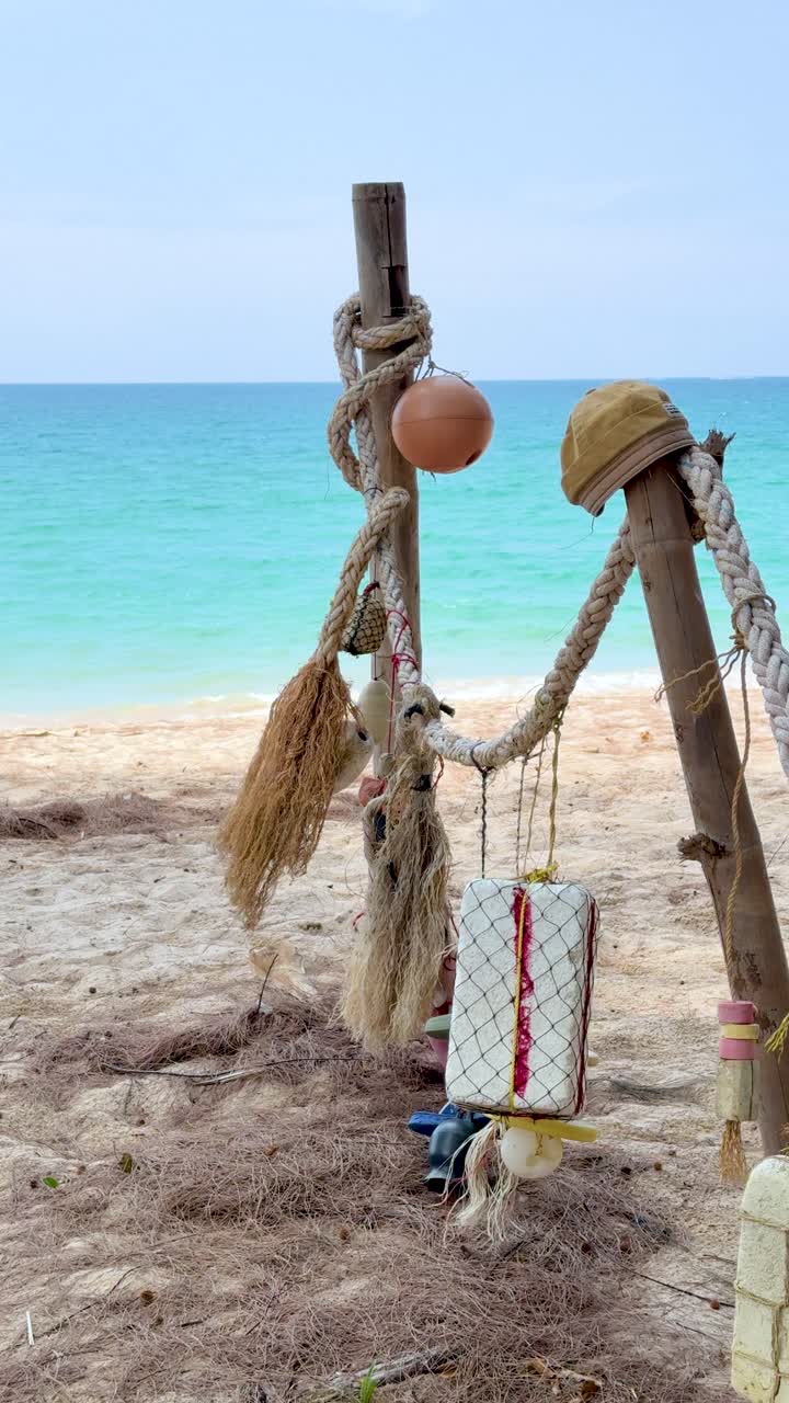 Inquadratura fissa di reti da pesca e corde su pali di legno sullo sfondo di un oceano tropicale
