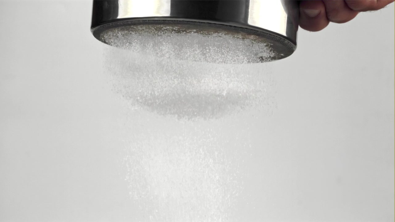 Azúcar glas tamizándose y cayendo en cámara lenta
