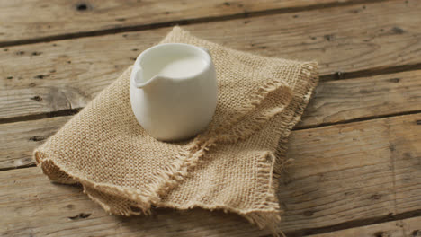 video de una jarra de vidrio de leche sobre un fondo de madera