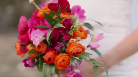 close up view of colorful floral bouquet in bride's hands at wedding