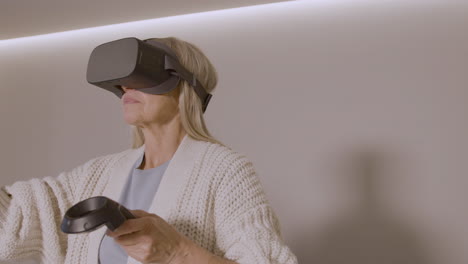 ältere-Frau,-Die-Zu-Hause-Mit-Virtual-reality-brillen-headset-Spielt-1