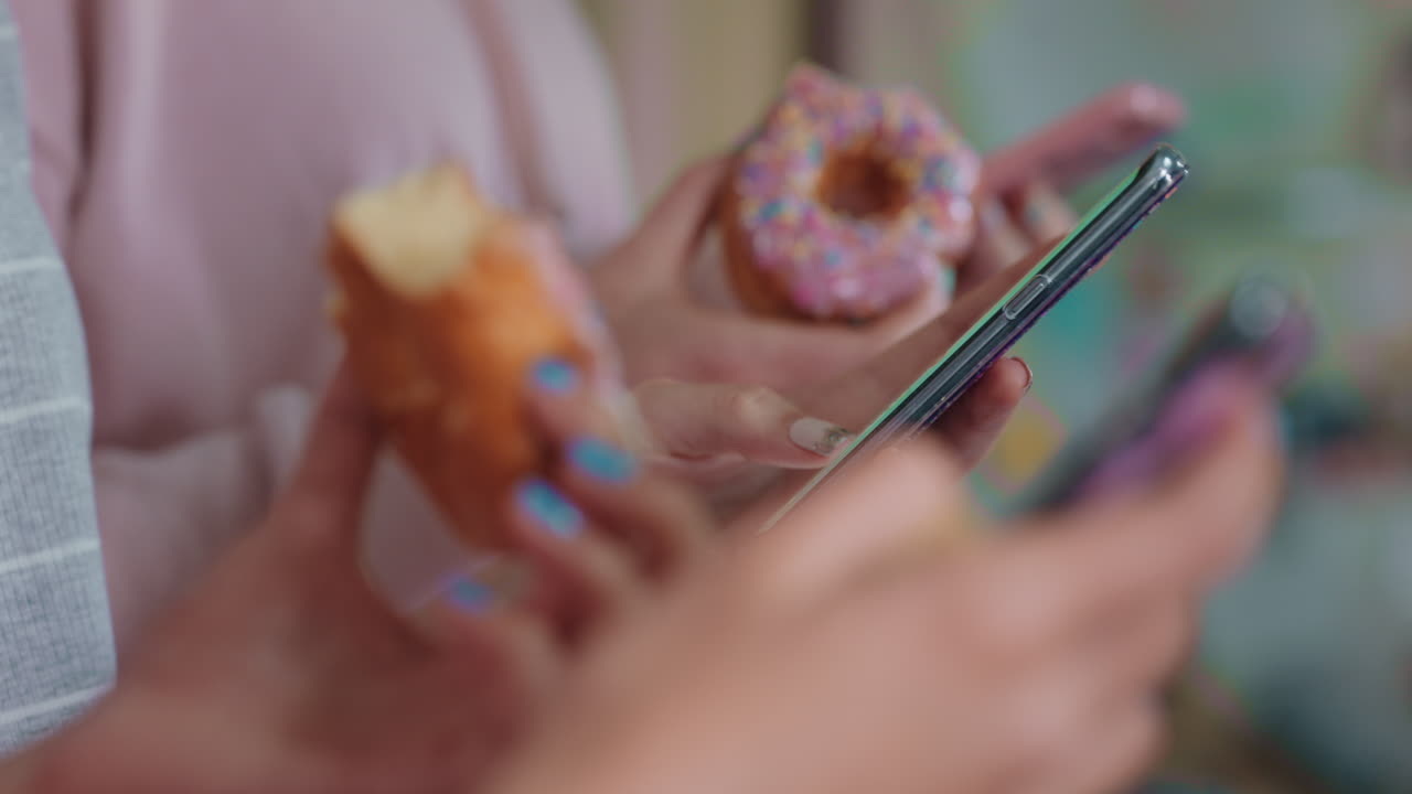 cerca de una adolescente que usa un teléfono inteligente navegando por las redes sociales enviando mensajes de texto a amigos saliendo a comer rosquillas