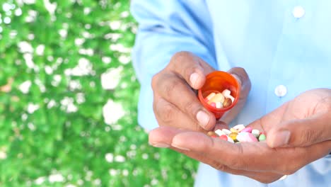 man pouring pills from bottle into hand