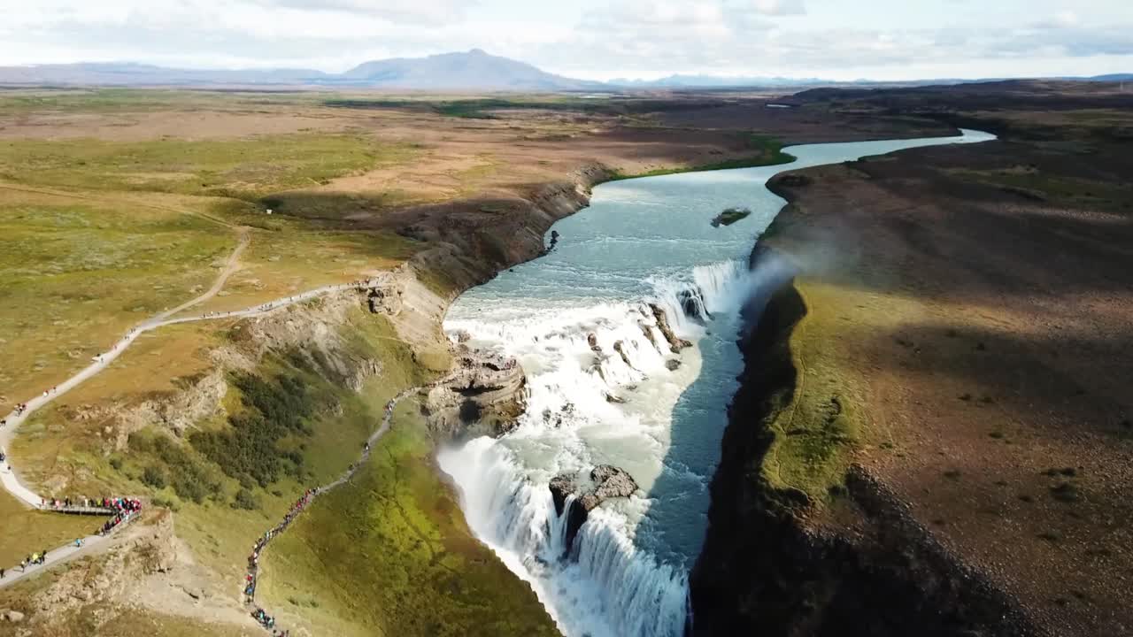 Gullfoss waterfall cascading through a canyon in Iceland, revealing a stunning landscape of pristine water and unique geological formations from an aerial perspective, drone aerial footage