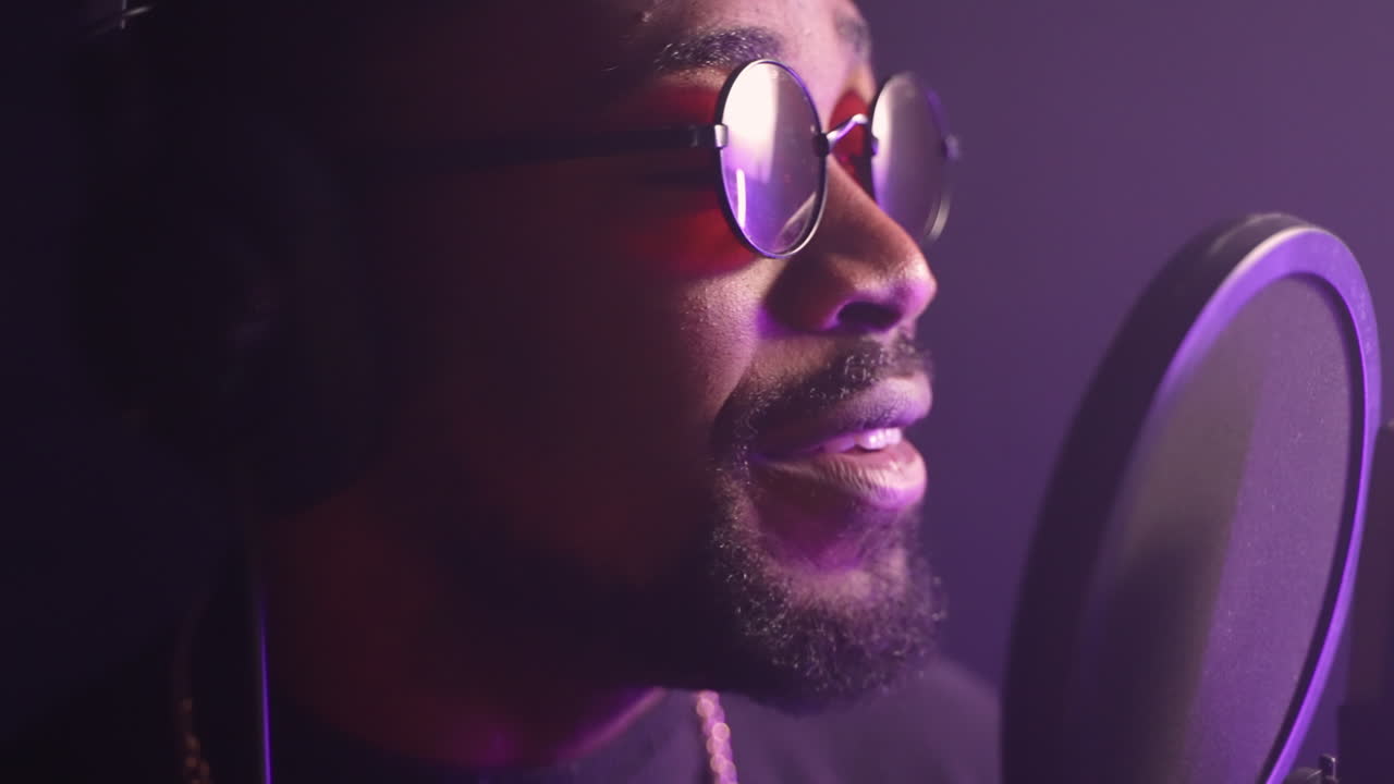 Man zingt in een microfoon in een opnamestudio