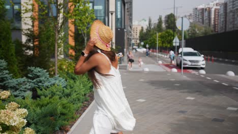 joven con un vestido blanco y un sombrero de paja