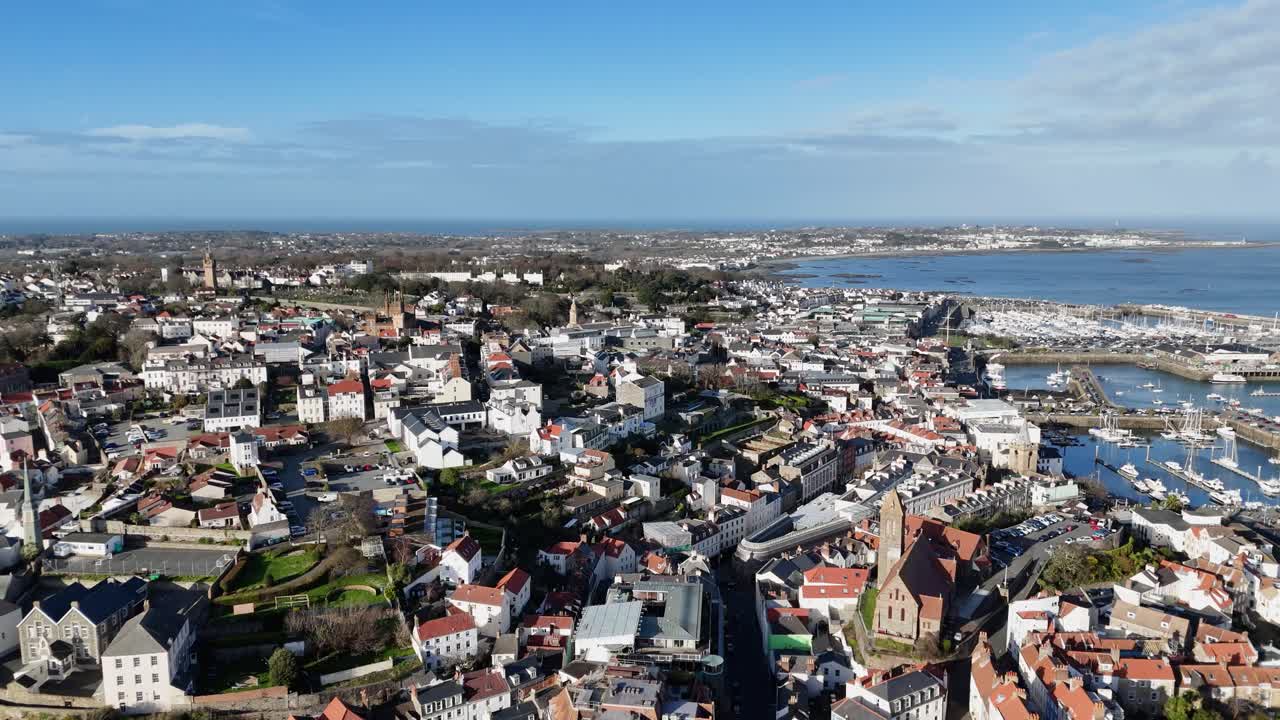 st. peter port guernsey revelación aérea colorida de la ciudad sobre el puerto mirando hacia el norte y tirando hacia el sur para revelar edificios casas jardines y perspectiva de la ciudad en un día soleado brillante
