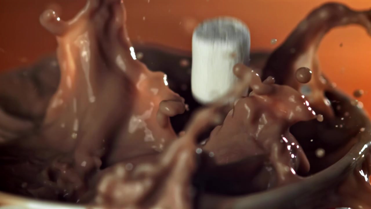Marshmallow in movimento rallentato che si tuffano nella cioccolata calda