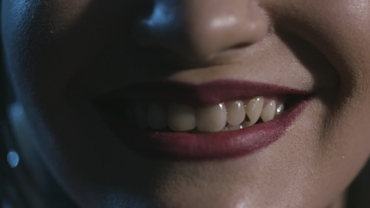primer plano de la boca sonriente de una mujer con lápiz labial rojo