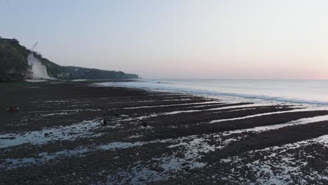 Disparo-De-Drones-En-ángulo-Bajo-Panorámica-Sobre-El-Arrecife-De-Marea-Baja-De-La-Playa-De-Bingin-Al-Atardecer-En-Uluwatu-Bali-Indonesia