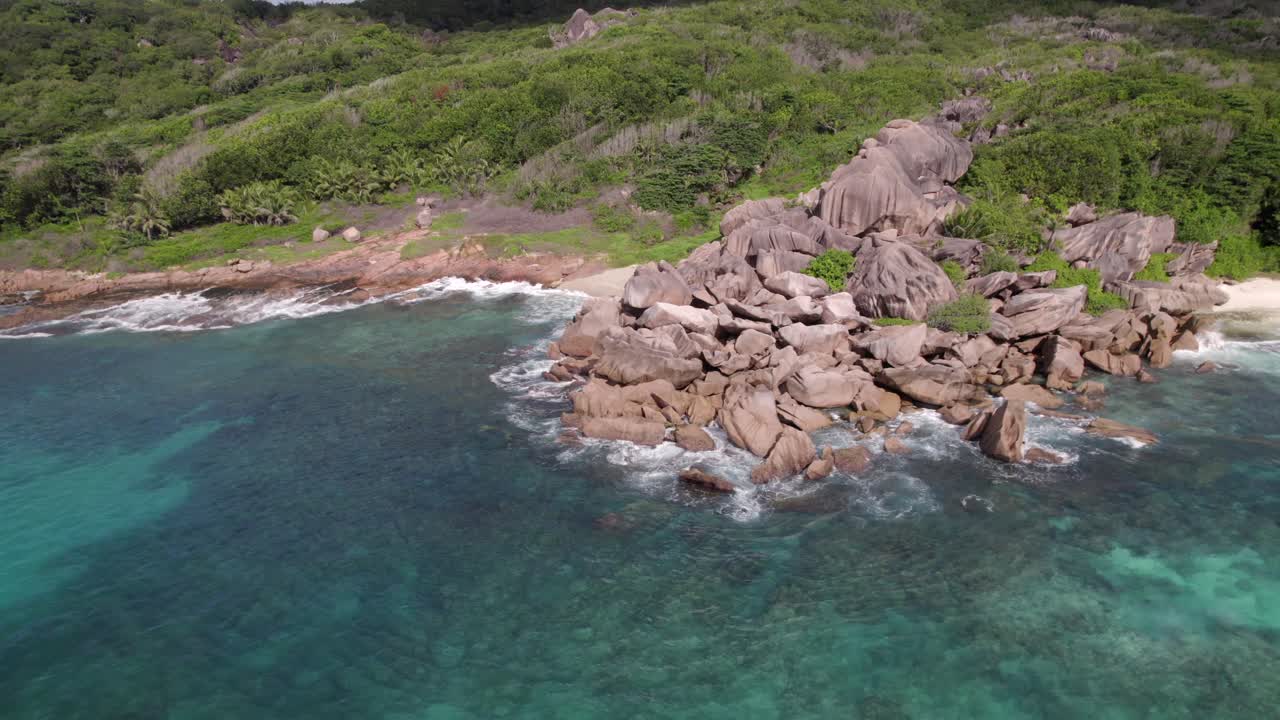 Grand Anse plajından, granit taşlardan, çarpan dalgalardan, el değmemiş doğadan drone görüntüsü, La Digue, Seyşeller 30fps 002