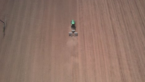 stunning aerial view of tractor flattening land with rollers, rising up top view