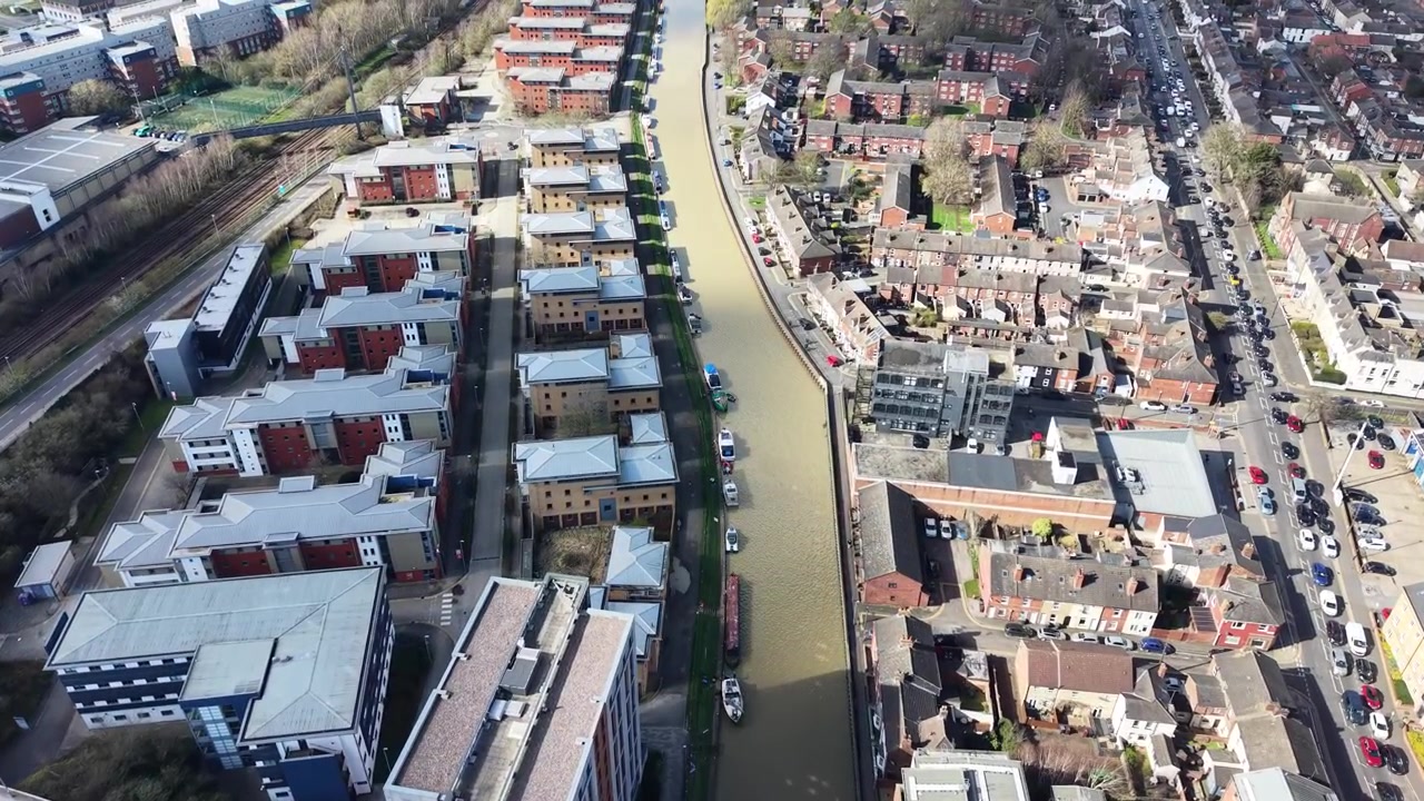 Vue aérienne par drone du Port flottant de Bristol à côté de Temple Meads, présentant un canal urbain, des immeubles d'appartements, des ponts et des rues animées de la ville.