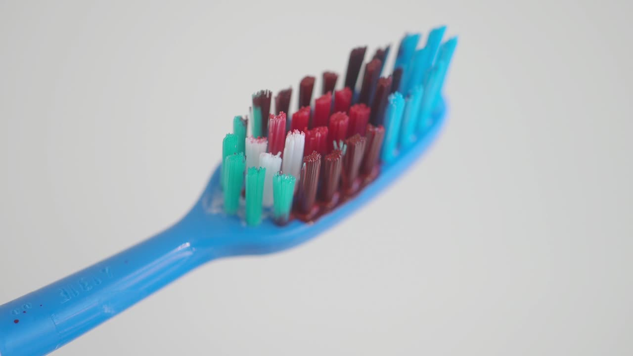 primer plano de un cepillo de dientes azul sucio y manchado