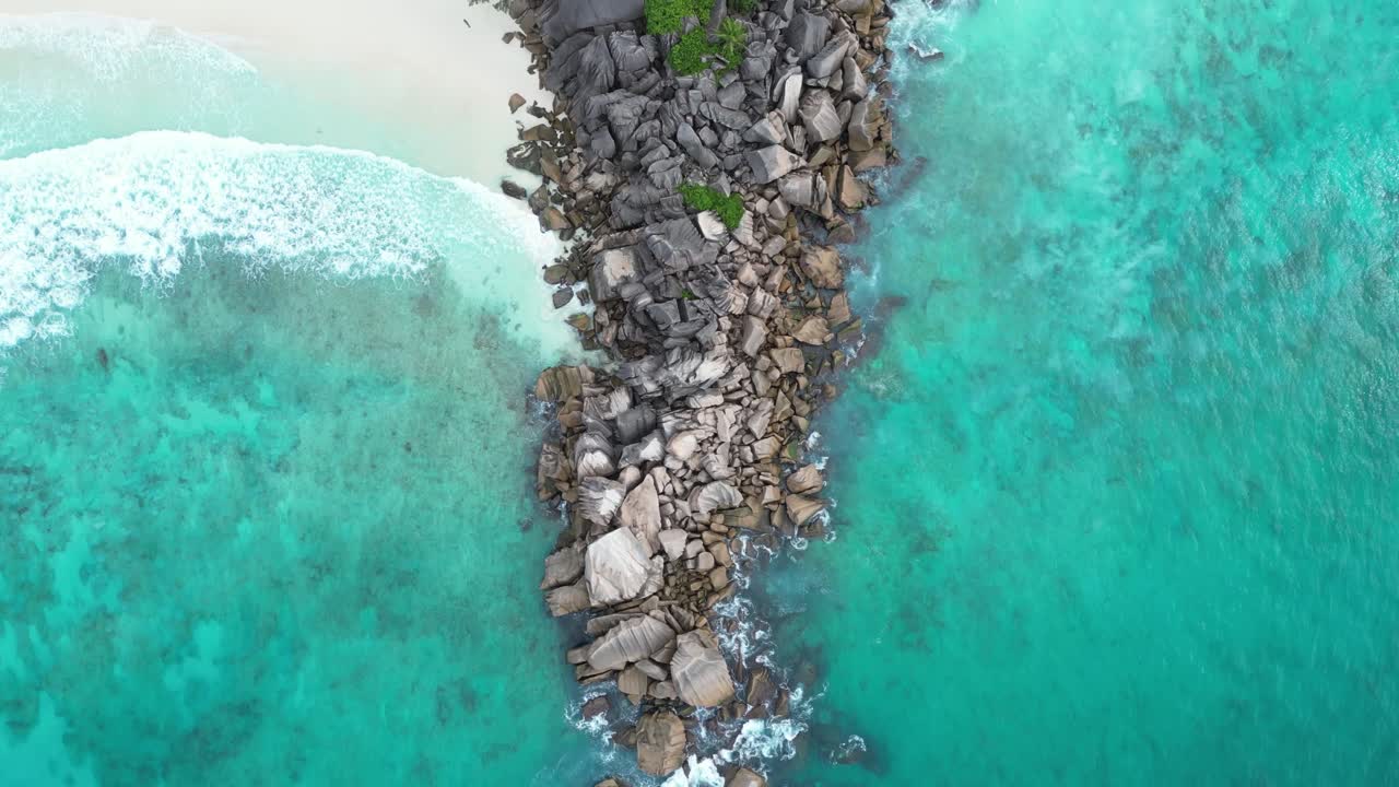 La Digue Island, Seychelles archipelago aerial top down waves crashing in to tropical white sand secluded lonely beach