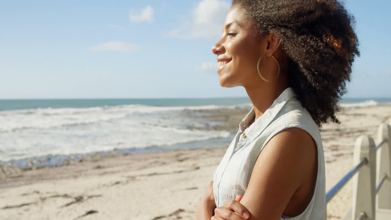 Woman standing with arms crossed at beach 4k