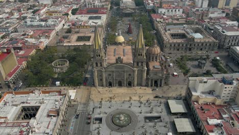 drone descends in front of historic guadalajara with people walking, catholic church of mexico