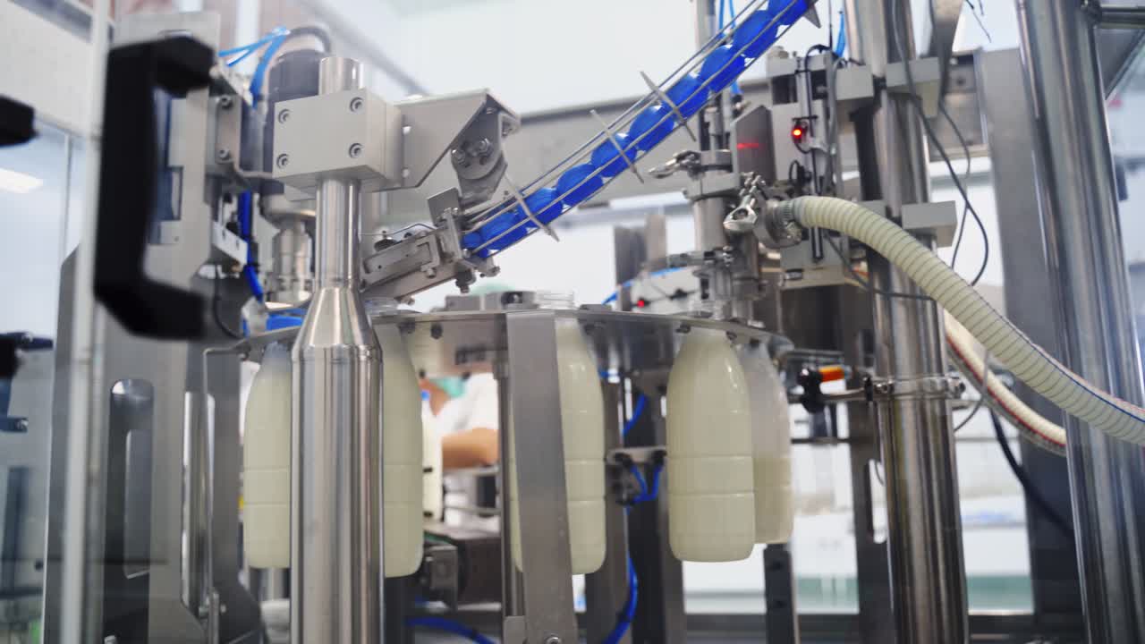 Production line at modernized dairy factory. Automated production line at milk factory. Milk pouring into plastic bottle at dairy plant.