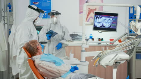 stomatologist in protective suit explaining dental radiography