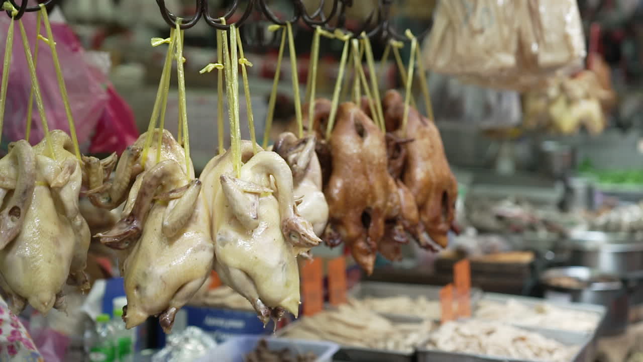 pollo entero asado cocido al vapor y patos colgando en el mercado húmedo fresco asiático