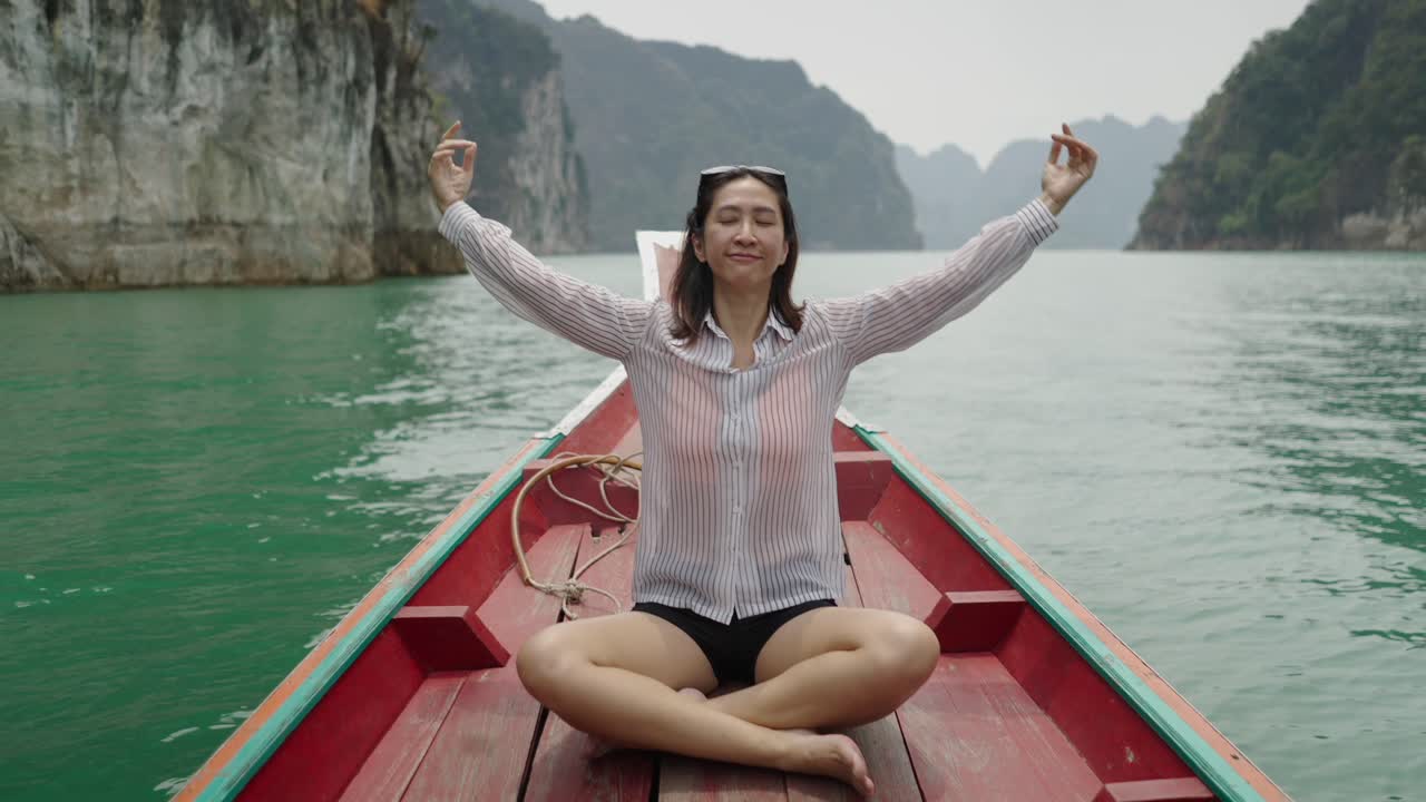 Woman Meditating on a Boat in a Serene Mountain Lake