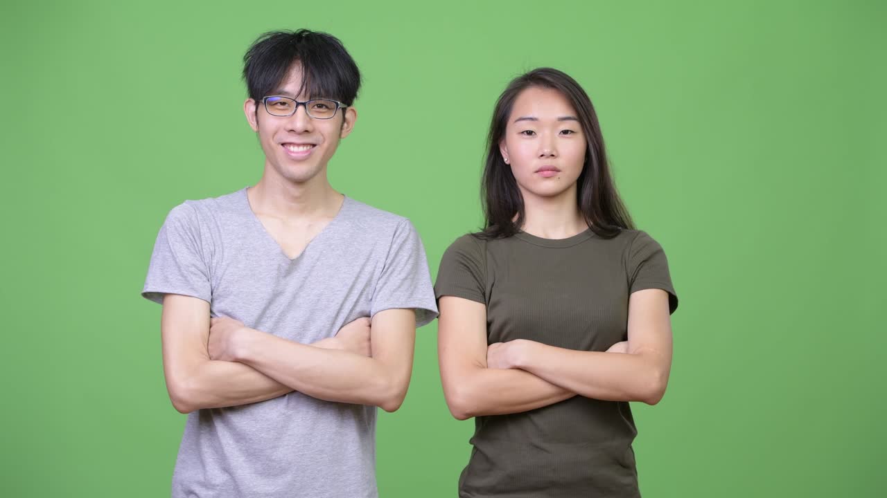 Young happy Asian couple together with arms crossed