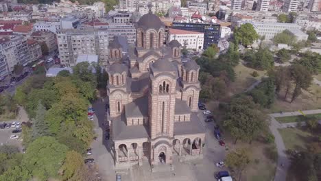Incredible-orbiting-4k-aerial-shot-of-St-Mark-Church-in-Tasmajdan-park,-Belgrade,-Serbia