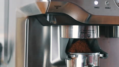 Hand-pushing-Portafilter-to-start-grinding-process-in-slow-motion