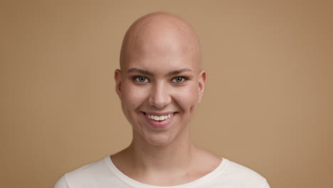 una mujer con una máscara, sonriente y calva.