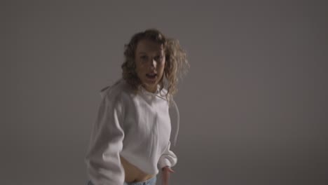 Studio-Shot-Of-Young-Woman-Having-Fun-Dancing-Against-Grey-Background-2