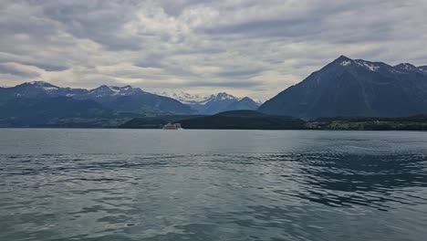 Static-shot-of-lake-Thun-with-boat-and-mountains-in-background-in-Switzerland