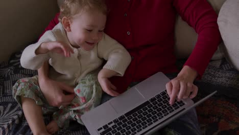 Kaukasische-Frau-Mit-Baby-Auf-Laptop-Zu-Hause