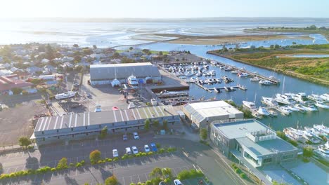Drone footage captures Queenscliff Marina, showcasing boats, buildings, and coastal landscape under bright daylight in Bellarine, Victoria