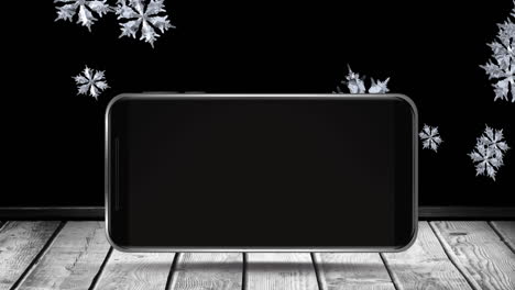 animation of blank smartphone screen with winter scenery and snowflakes falling on wooden surface