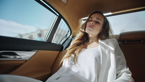 retrato de una mujer de negocios cansada relajándose en el asiento trasero de un automóvil moderno.