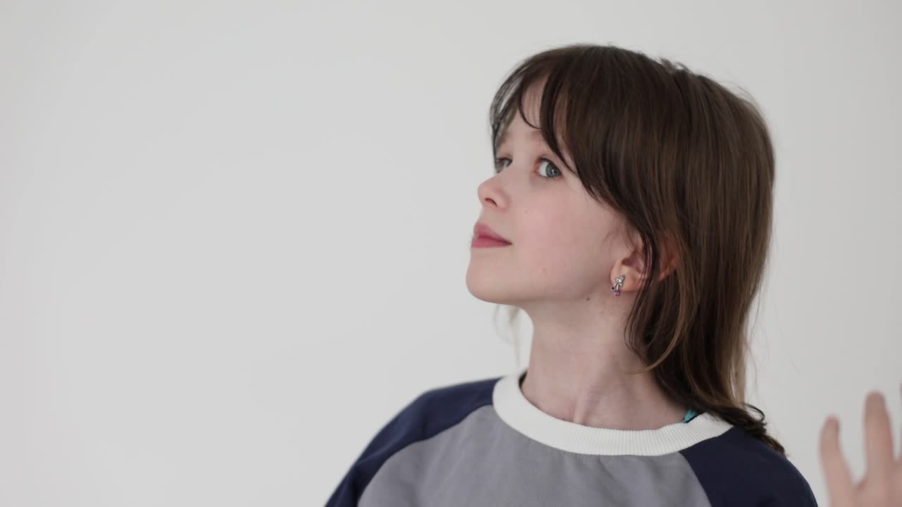 Portrait of a young boy looking up against a white background