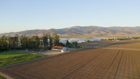 forqward and pan left of large farmland with mountains in the background in salinas valley, ca