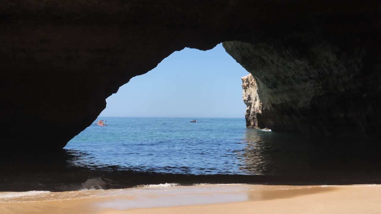 Tourists paddling kayaks in the Atlantic outside of Algarve caves beach